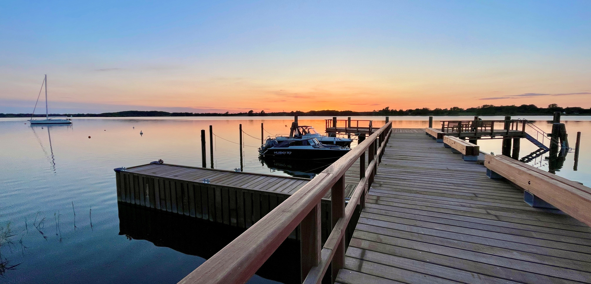 langer Holzsteg an der Schlei bei Sonnenuntergang